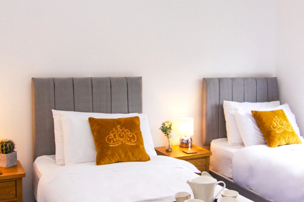 Neatly appointed single beds in a twin-style setup within our self-catering lodge, providing practical and restful accommodation for guests visiting Hays Wood Retreat, Norfolk.