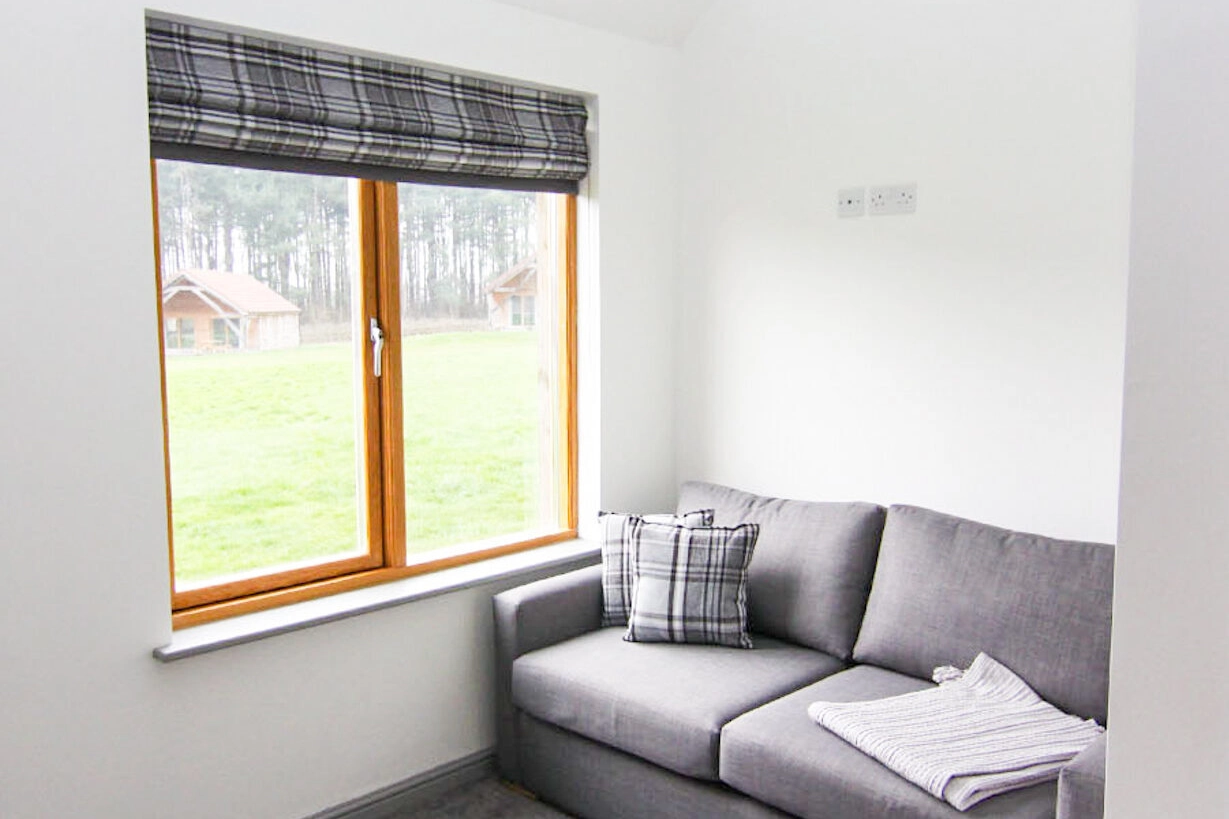 A comfortable sofa bed positioned in a bedroom of our lodge at Hays Wood Retreat, providing flexible sleeping options for additional guests or children during your Norfolk stay.