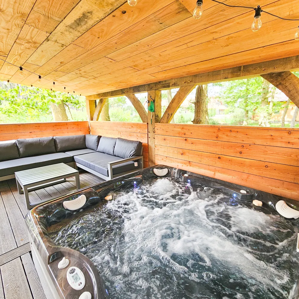 Close-up of a bubbling hot tub on the private patio of a luxury hot tub lodge at Hay’s Wood Retreat in Norfolk, UK. Perfect for relaxing countryside escapes, these hot tub lodges offer guests the ideal way to unwind in peaceful surroundings, making Hay’s Wood one of Norfolk’s favourite destinations for hot tub breaks, romantic getaways, and family stays with added comfort.