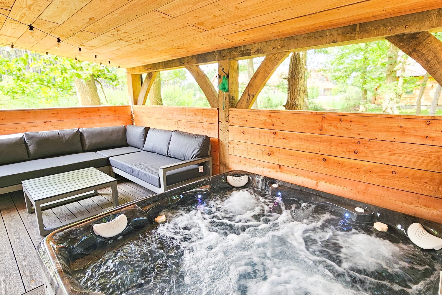 Close-up of a bubbling hot tub on the private patio of a luxury hot tub lodge at Hay’s Wood Retreat in Norfolk, UK. Perfect for relaxing countryside escapes, these hot tub lodges offer guests the ideal way to unwind in peaceful surroundings, making Hay’s Wood one of Norfolk’s favourite destinations for hot tub breaks, romantic getaways, and family stays with added comfort.