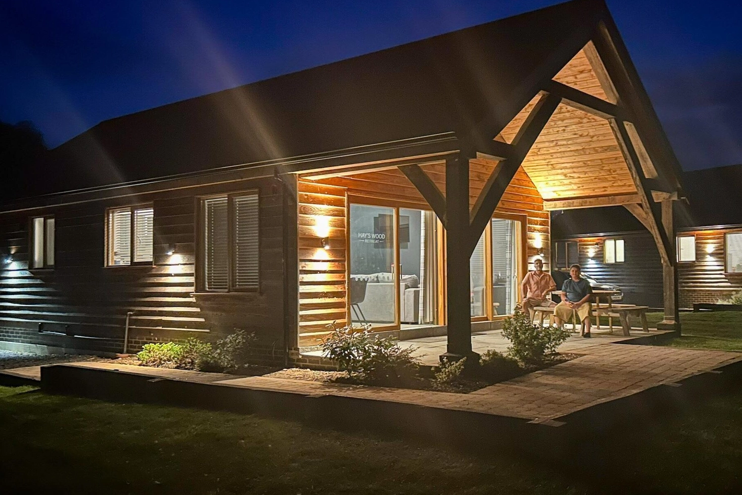 An inviting two-bedroom holiday lodge at Hays Wood Retreat, glowing softly at night, perfect for tranquil escapes and romantic breaks under the Norfolk stars.